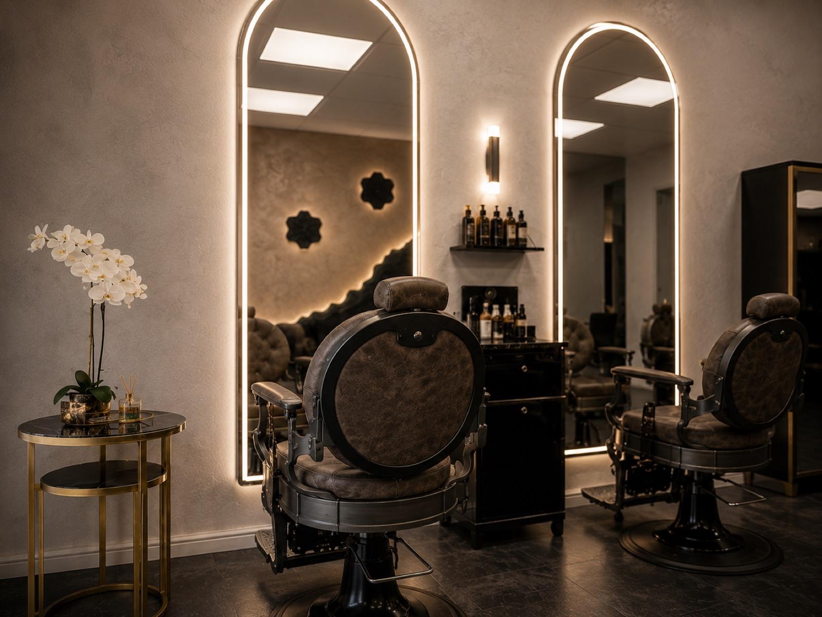 Two vintage barber chairs facing arched, backlit mirrors at Empire unisex salon in Corby