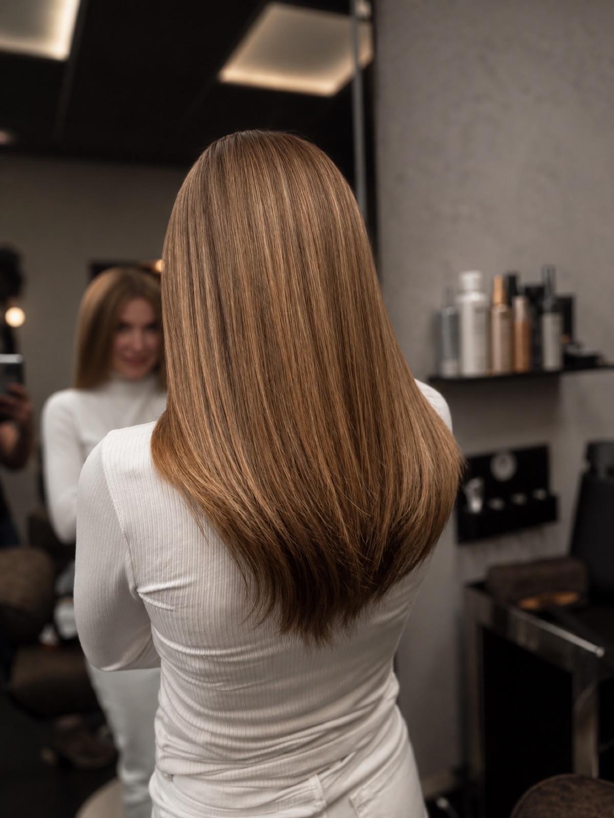 Long caramel-brunette hair finished with a sleek, glossy blow-dry