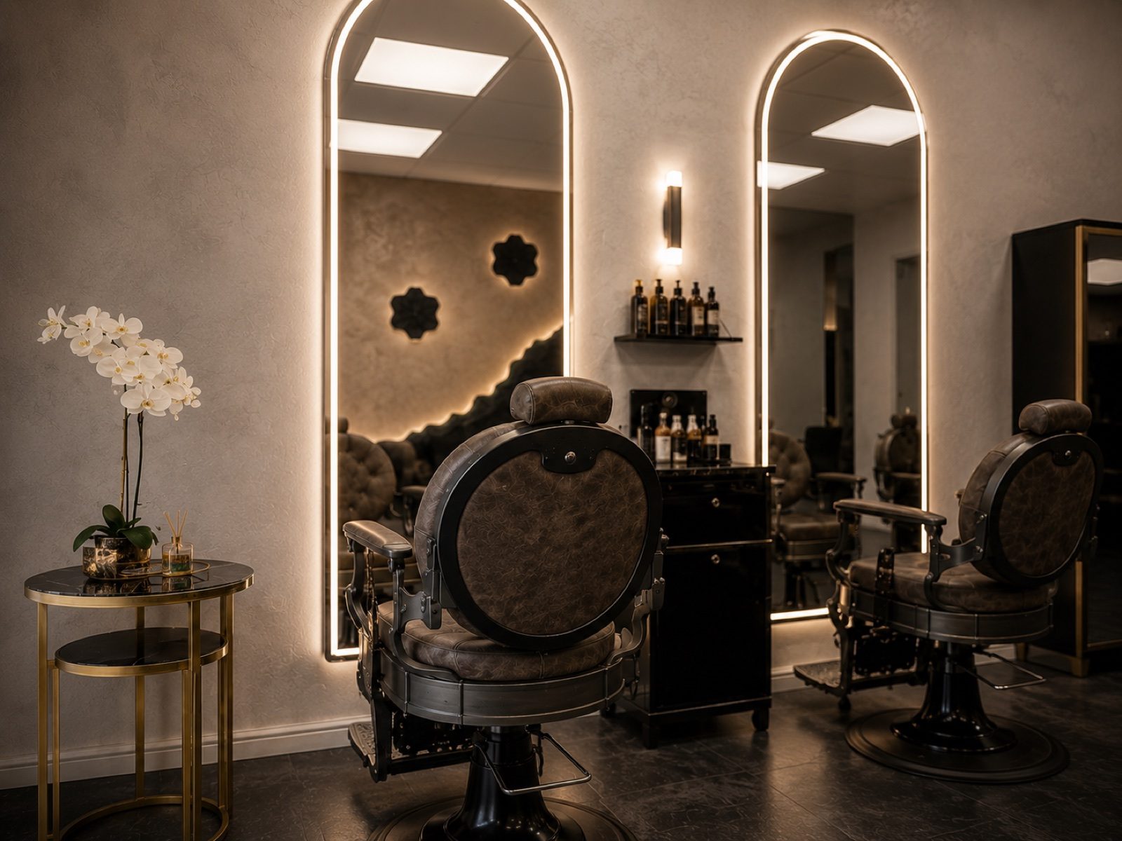 Two vintage barber chairs facing arched, backlit mirrors at Empire unisex salon in Corby
